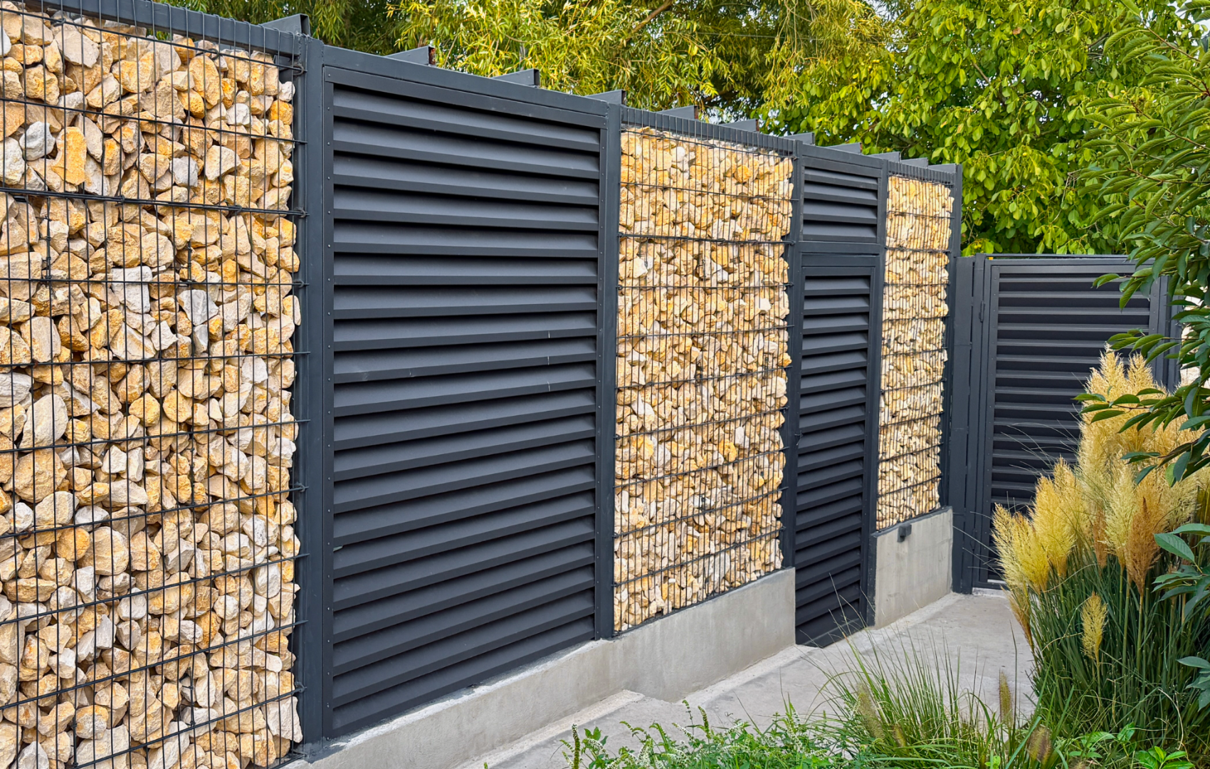 Gard tip panou jaluzea ATLAS, gri antracit montat intre stalpi din piatra gabion